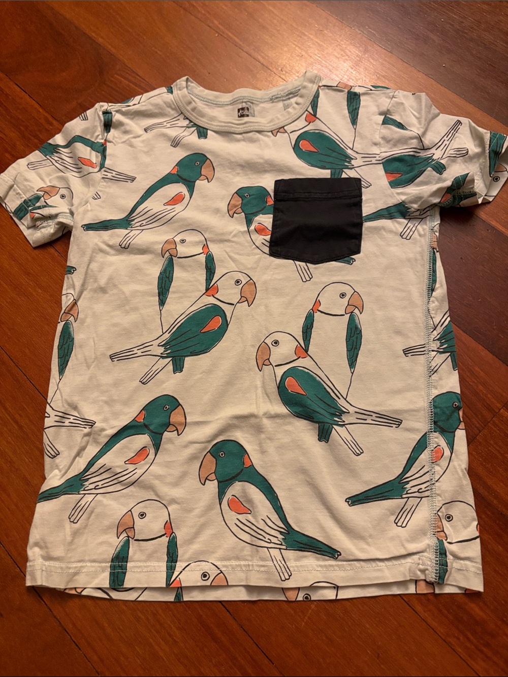 Tea Collection Cream Tee with Teal & Orange Parrot Print and Black Pocket